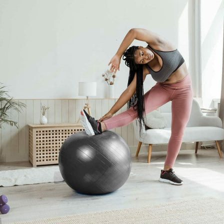 Ballon pilates gris femme fait des exercices a la maison