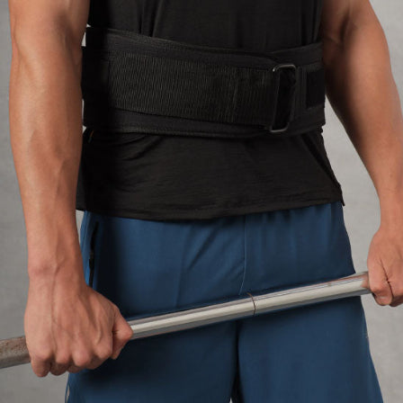 Un homme portant une ceinture de force et tenant une barre de musculation.
