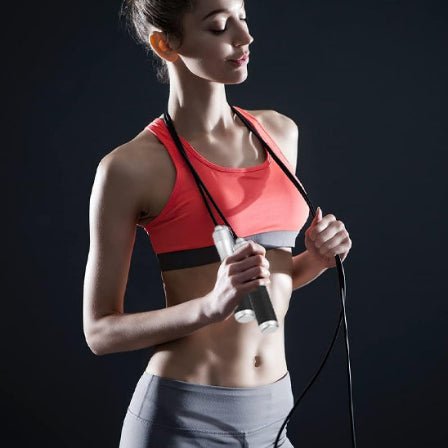 Femme relaxe avec corde a sauter autour du cou