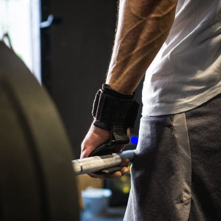 Sange de tirage Un homme en position de deadlift tient une barre avec force, prĂȘt Ă soulever un poids important.