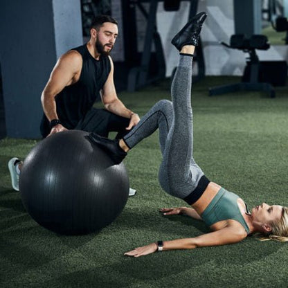 Ballon pilates noir et couple qui fait des exercices exterieur