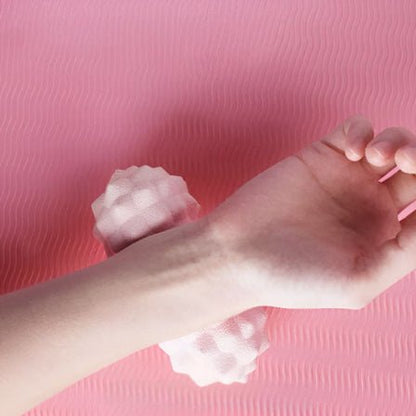 boule de massage couleur rose et une femme qui messe sn poignet