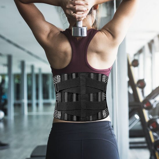 Une femme portant une ceinture lombaire s'exerce dans une salle de sport.