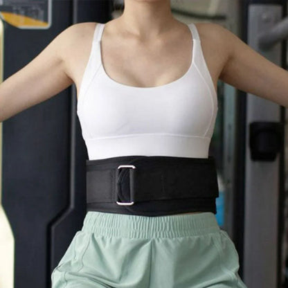 Femme portant une ceinture de force dans une salle de sport, concentrée sur son entraînement.