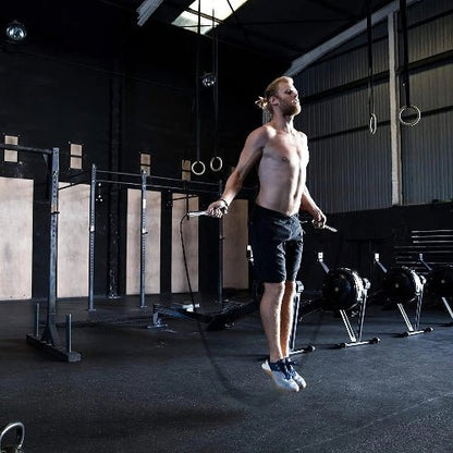 Homme fait corde a sauter dans salle de crossfit