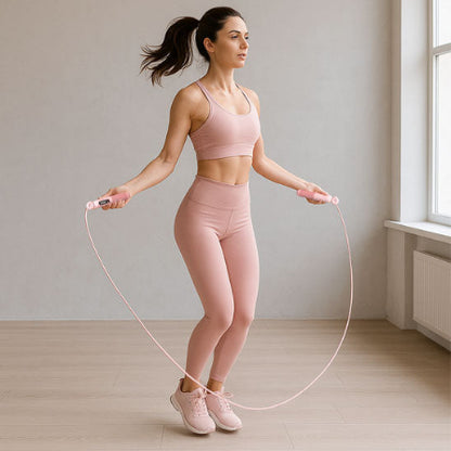 Femme avec un top rose pratique corde a sauter
